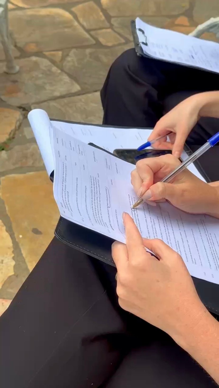 Mãos preenchendo um checklist durante a montagem de um evento